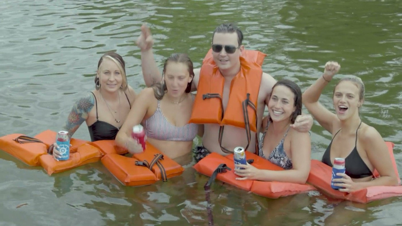 Guests floating in the lake on orange life vests